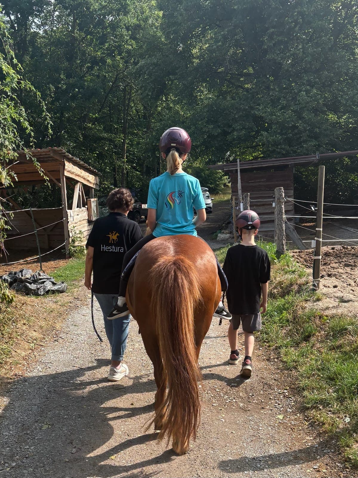 Kleine Gruppe verlässt mit einem Pony das Hofgelände